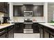 Contemporary kitchen showcasing stainless steel appliances, dark wood cabinetry, and bright countertops at 841 Benjamin Trl, Davenport, FL 33837