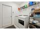 Functional laundry room equipped with modern washer, dryer, storage shelves, and tiled floor at 841 Benjamin Trl, Davenport, FL 33837