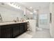 Well-lit main bathroom featuring double sinks, a tiled walk-in shower, and neutral decor at 841 Benjamin Trl, Davenport, FL 33837