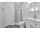 Well-lit bathroom with a glass shower enclosure, white cabinets, and modern fixtures over gray floors at 9332 Windy Ridge Rd, Windermere, FL 34786