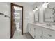 Bathroom featuring a double sink vanity with white cabinets, and a door opening to the toilet at 9332 Windy Ridge Rd, Windermere, FL 34786