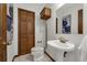 Vintage-style bathroom with a pedestal sink, a wall mirror, and an elevated toilet at 9332 Windy Ridge Rd, Windermere, FL 34786