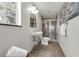 Bright bathroom features pedestal sink, decorative mirror, glass door shower, and tile floor at 9332 Windy Ridge Rd, Windermere, FL 34786