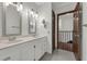 Bathroom featuring a double sink vanity with white cabinets, a mirror, and wood-look tile floor at 9332 Windy Ridge Rd, Windermere, FL 34786