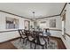 Stylish dining room boasts a wooden table with seating, complemented by elegant artwork and natural light from a large window at 9332 Windy Ridge Rd, Windermere, FL 34786