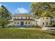 Charming two-story home featuring a full wrap-around porch and a bright blue front door at 9332 Windy Ridge Rd, Windermere, FL 34786