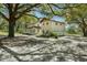 Two-story house with a wrap-around porch, a side building with a garage and mature trees at 9332 Windy Ridge Rd, Windermere, FL 34786