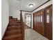 Welcoming foyer with beautiful wood staircase and leaded glass entry door at 9332 Windy Ridge Rd, Windermere, FL 34786