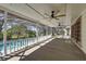 Covered porch with ceiling fans, wood flooring, and a view of the pool and backyard at 9332 Windy Ridge Rd, Windermere, FL 34786