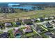 Beautiful aerial view of the neighborhood with a lake in the background and a home with a pool at 9716 Royal Vista Ave, Clermont, FL 34711