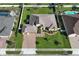 Overhead view of a well-maintained property boasting a brick driveway, manicured lawn, and a two-car garage at 9716 Royal Vista Ave, Clermont, FL 34711