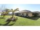 Spacious backyard featuring green lawn, palm tree, partial fence, and the rear exterior of the house at 9716 Royal Vista Ave, Clermont, FL 34711