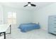 Well-lit bedroom featuring tile floors, a ceiling fan, and a light-blue dresser at 9716 Royal Vista Ave, Clermont, FL 34711