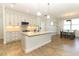 Bright, open kitchen featuring white cabinetry, stainless steel appliances, and a large center island at 9716 Royal Vista Ave, Clermont, FL 34711