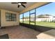 Spacious screened-in patio with brick floor and a view of the lush backyard at 9716 Royal Vista Ave, Clermont, FL 34711