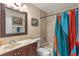 Well-lit bathroom with a vanity, toilet, framed art, and a shower with a colorful curtain at 978 Cobbler Ct, Longwood, FL 32750