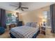 Comfortable bedroom features a ceiling fan, large window, curtains, and a blue and white plaid comforter at 978 Cobbler Ct, Longwood, FL 32750