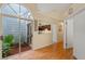 Bright hallway featuring hardwood floors, a view into a courtyard, and access to the kitchen at 978 Cobbler Ct, Longwood, FL 32750