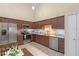 Kitchen with stainless steel appliances, stone countertops, dark cabinets, and tile floors at 978 Cobbler Ct, Longwood, FL 32750