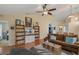 Living room with wood flooring, a ceiling fan, and shelving surrounding the television at 978 Cobbler Ct, Longwood, FL 32750