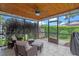 Inviting screened-in patio with wicker furniture, ceiling fan, and views of the lush backyard at 978 Cobbler Ct, Longwood, FL 32750