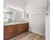 Bright bathroom featuring a double sink vanity with wood cabinets and a shower with glass doors at 1018 Highland Meadows St, Davenport, FL 33837