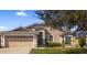 Charming single-story home featuring a two-car garage, well-maintained landscaping, and a welcoming facade at 1018 Highland Meadows St, Davenport, FL 33837