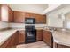 Efficient kitchen layout with dark appliances, laminate countertops, and convenient access to dining and living areas at 1018 Highland Meadows St, Davenport, FL 33837