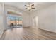 Spacious living room featuring sleek floors, a ceiling fan, and sliding glass doors to the lanai at 1018 Highland Meadows St, Davenport, FL 33837