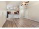 An open floor plan showcasing the living area and kitchen featuring vaulted ceilings and laminate flooring at 1018 Highland Meadows St, Davenport, FL 33837