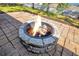 Outdoor stone fire pit sitting on a brick patio, perfect for entertaining in a fenced backyard at 11706 Regal Ridge Ln, Clermont, FL 34711