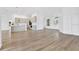 Open-concept living area with wood floors, white walls, and modern fixtures, leading into the kitchen at 11706 Regal Ridge Ln, Clermont, FL 34711