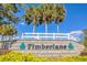 Community entrance sign with the name 'Timberlane', framed by green foliage and clear skies at 11706 Regal Ridge Ln, Clermont, FL 34711