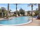 Community pool area featuring mature palm trees and ample seating in a tropical setting at 12008 Villanova Dr # 112, Orlando, FL 32837