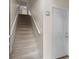 Carpeted staircase with white railing leading upstairs, adjacent to a white entrance door at 12008 Villanova Dr # 112, Orlando, FL 32837
