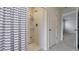 Clean bathroom featuring a walk-in shower with shelves and a stylish striped shower curtain at 1210 Alstonia Ln, Mount Dora, FL 32757