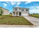 Charming two-story home with a well-manicured lawn, attached two-car garage, and inviting blue front door at 1210 Alstonia Ln, Mount Dora, FL 32757
