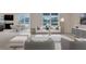 Bright living room featuring stylish furniture, large windows, and an adjacent dining area with views of the pond at 1210 Alstonia Ln, Mount Dora, FL 32757