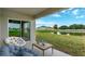 Relaxing covered patio offers serene views of the pond and backyard with comfortable outdoor seating at 1210 Alstonia Ln, Mount Dora, FL 32757