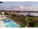 Beautiful view of the lake, dock, and pool with fireworks at dusk at 14544 Avenue Of The Rushes, Winter Garden, FL 34787