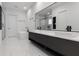 Modern bathroom with a soaking tub, dual vanities, sleek black fixtures, and a large mirror at 14544 Avenue Of The Rushes, Winter Garden, FL 34787