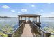 Picturesque lake view featuring a private wooden dock with a covered seating area at 14544 Avenue Of The Rushes, Winter Garden, FL 34787