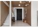 Bright entryway with a modern chandelier, a black front door, and a staircase at 14544 Avenue Of The Rushes, Winter Garden, FL 34787