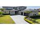 Stunning two-story home with well-manicured lawn, paver driveway, and black garage doors at 14544 Avenue Of The Rushes, Winter Garden, FL 34787