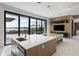Contemporary kitchen with island sink, large sliding doors to a patio, and an adjacent living area with a mounted TV at 14544 Avenue Of The Rushes, Winter Garden, FL 34787