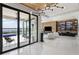 Open living room with marble floors, modern light fixture, and sliding doors to an outdoor patio and pool at 14544 Avenue Of The Rushes, Winter Garden, FL 34787