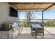 Outdoor kitchen featuring stainless steel appliances, grill, and dining area with lake views at 14544 Avenue Of The Rushes, Winter Garden, FL 34787