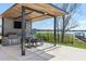Outdoor kitchen featuring a dining area, lake view, and mounted television for entertainment at 14544 Avenue Of The Rushes, Winter Garden, FL 34787