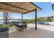 Outdoor covered patio with dining and lounge seating, barbecue, and pool overlooking the lake at 14544 Avenue Of The Rushes, Winter Garden, FL 34787