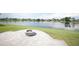 Beautiful backyard features a brick patio with a fire pit overlooking a tranquil lake at 14712 Eagles Crossing Dr, Orlando, FL 32837